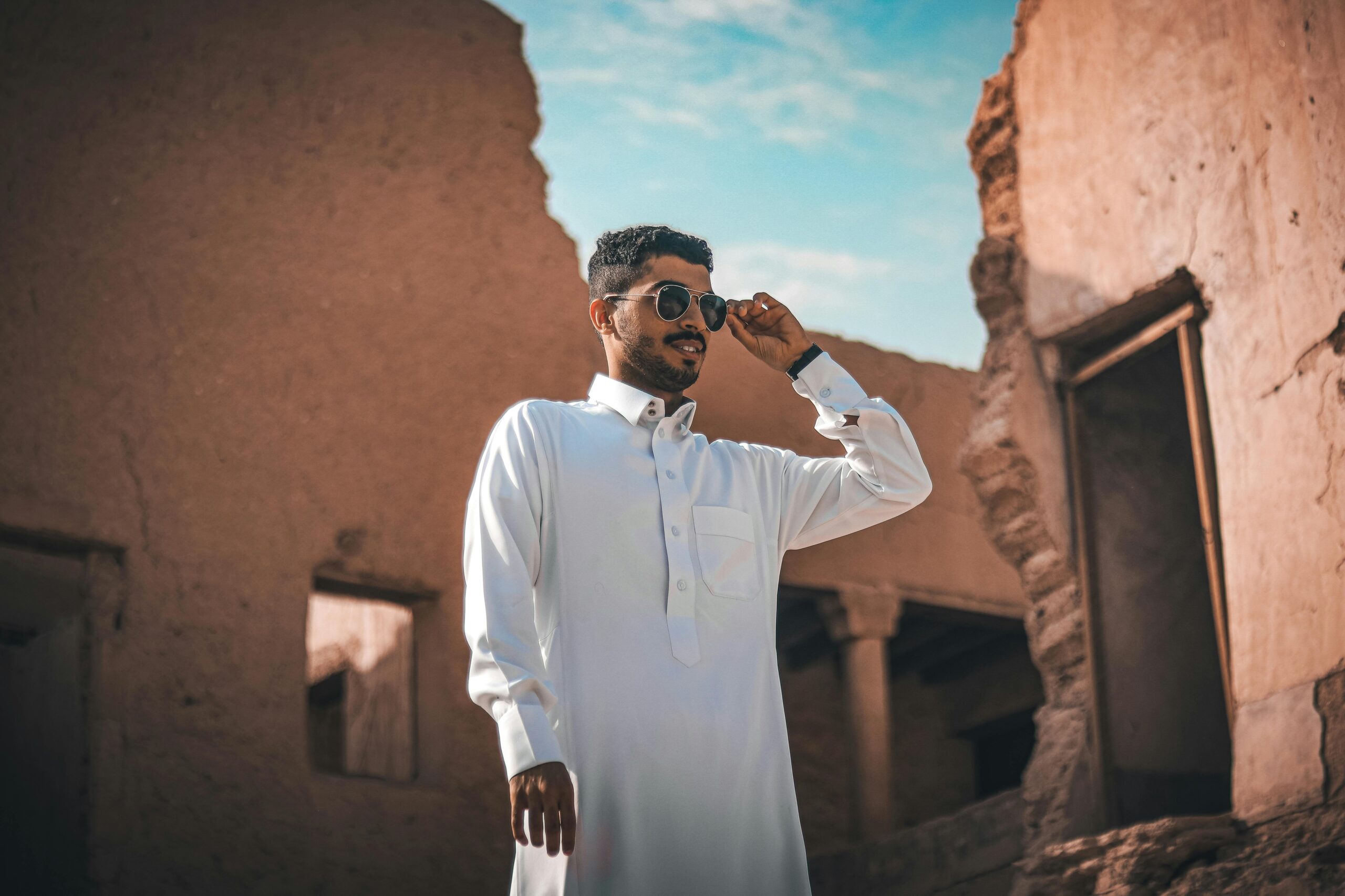 Home Man in sunglasses explores ancient ruins in Riyadh. Cultural and urban exploration captured.