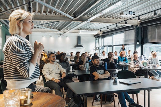 Our Services A dynamic speaker engaging a diverse audience in a modern workshop setting.