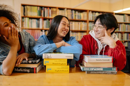 Our Services Three diverse students laughing and studying together in a cozy library setting.